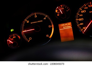 Red Car Tachometer in the dark. Symbol of speed. Dashboard with speedometer, tachometer, odometer. Car detailing. Car dashboard. Dashboard details with indication lamps.Car instrument panel