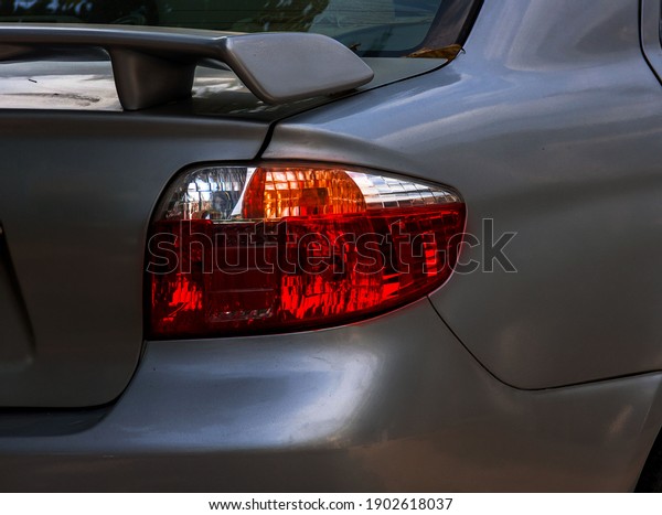 Red car\
tail light Detail on the rear light of a gray carCloseup of rear\
light of car isolated on white background, Clipping path\
included.Close up of rear taillight on a\
vehicle.