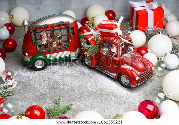 red car with\
trailer trailer with santa claus driving on gray background with\
christmas decor with snow\

