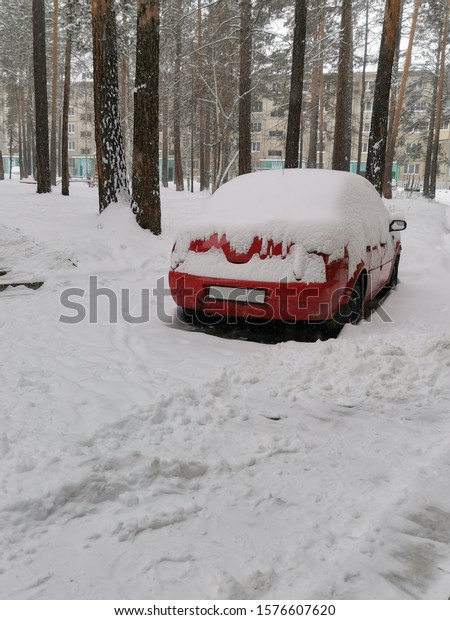 red car in the yard\
covered with snow