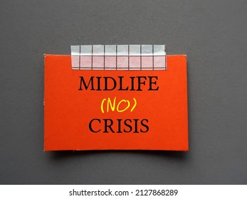 Red card stick on wall with handwritten text MIDLIFE NO CRISIS - to overcome crisis on transition of identity and self-confidence usually occur in middle-aged 45 to 65 years old
