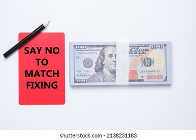 A red card written say no to match fixing and fake dollar insight. War against match fixing concept.