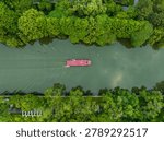 Red cargo barge navigating through turquoise waters surrounded by lush green forest along Hangzhou