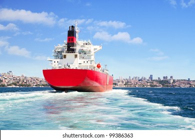 Red Cargo Ship Sailing In To The Sea