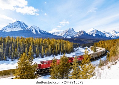 Red cargo train passing through Morant's curve in Bow Valley inside Banff National Park. Beautiful snowy winter landscape in the Canadian rockies of Alberta with Mount Temple in the background. - Powered by Shutterstock