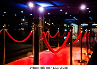 Red carpet with  barriers, velvet ropes and lights in the background - Powered by Shutterstock