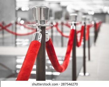 Red Carpet fence pole with red ropes Blurred interior background