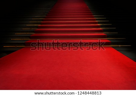 Red carpet on the stairs on a dark background. The path to glory, victory and success