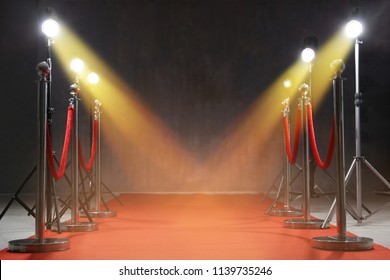 Red carpet, rope barriers and spot lights indoors