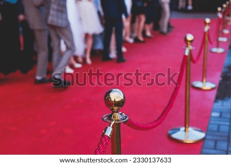 Red carpet with ropes and golden barriers on a luxury party entrance, cinema premiere film festival event award gala ceremony, wealthy rich guests arriving, outdoor decoration elements, summer day