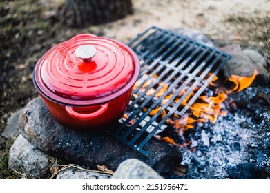 Red Cast Iron Pot (dutch Oven) Beside An Open Fire.