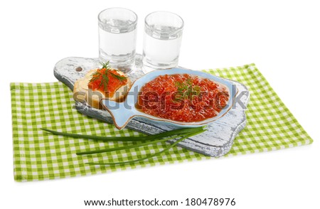 Red caviar in bowl and vodka on wooden board , on napkin isolated on white