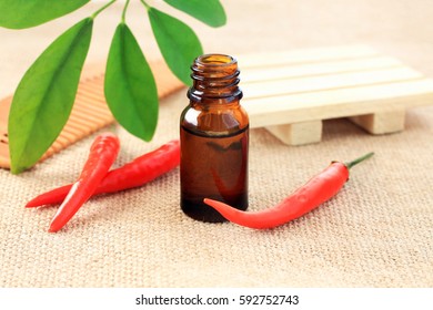 Red Cayenne Chili Pepper Extract Benefits For Hair And Skin. Bottle Of Lotion, Bright Fresh Pods, Green Leaf Decor