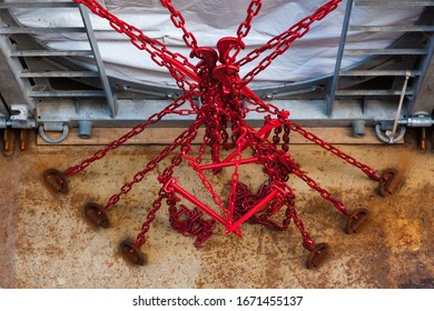 Red chains hold an important load while transporting it by sea.