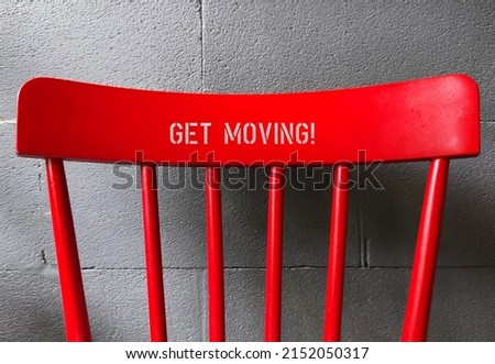 Red chair back with text GET MOVING!, concept of having difficulty setting aside exercise time, reminder for health improvement by being more physically active