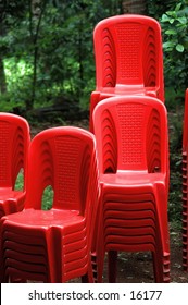 Red chairs stacked out on a cloudy monsoon day