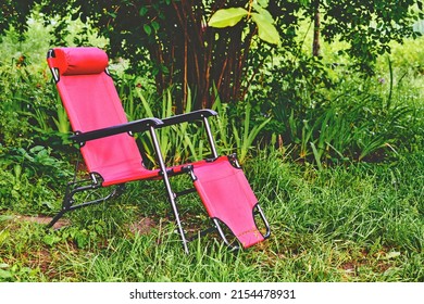 Red Chaise Lounge Chair On Summer Green Meadow