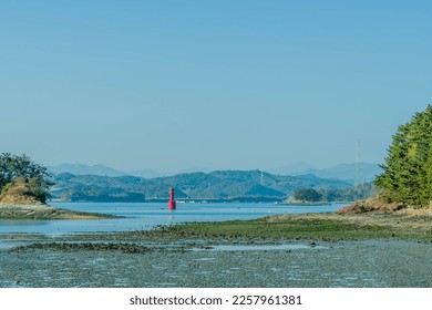 Red channel marker beacon between two islets at low tide. - Shutterstock ID 2257961381