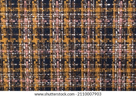 Red checkered fabric with colored threads. Scottish wool. Fabric for a plaid coat and suit. Close-up. Background