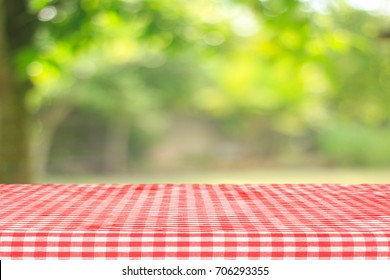 Roter karierte Tischdecke Draufsicht mit abstraktem grünem Bokeh aus Garten im Morgenhintergrund.Für die Montage Produkt-Display oder Design-Schlüssel visuellen Layout und Sommersaison.