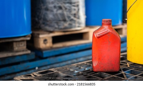 A red chemical or lube oil bottle without safety sign information sign attached, it placed in warehouse chemical storage area. Industrial unsafe working place and object photo.