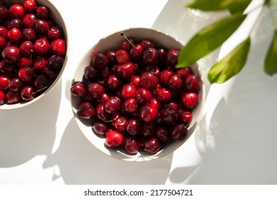 Red Cherries On A Plate With Long Shadows On White Background. Fruit On A Table Close Up. Flat Lay Styling