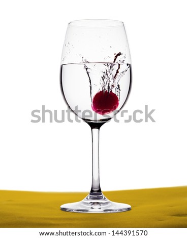 red cherry drop into the water in wine glass
