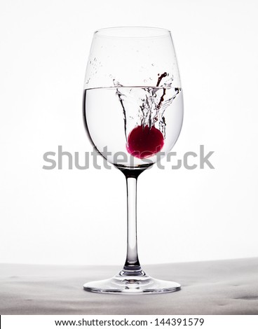 red cherry drop into the water in wine glass