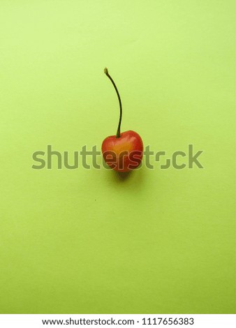 red cherry on a yellow table