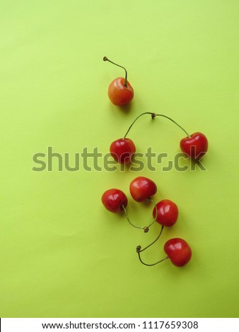 red cherry on a yellow table