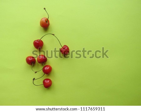 red cherry on a yellow table