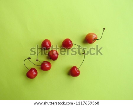 red cherry on a yellow table