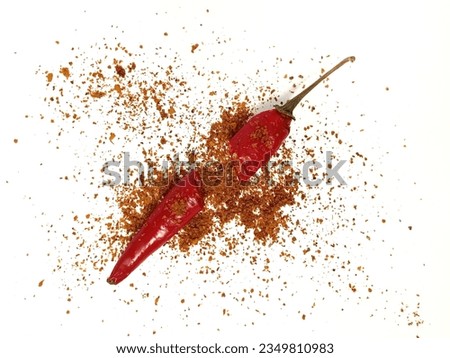 Red chili explode with chili powder and pepper flakes scattered on isolated white background