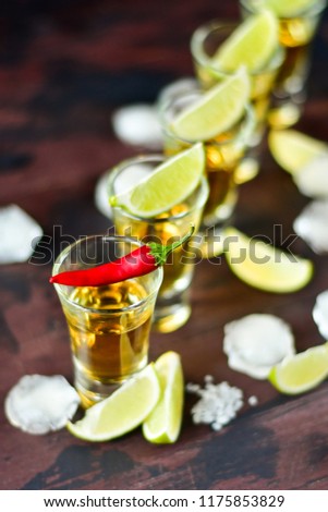 Red chili on a glass of alcohol, five glasses of alcohol and lime, a party at the bar, a menu for the bar. Selective focus and copy space
