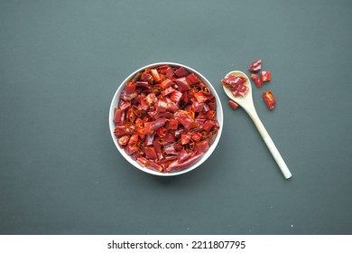 Red Chili Pepper Flakes In A Bowl On Black Background .