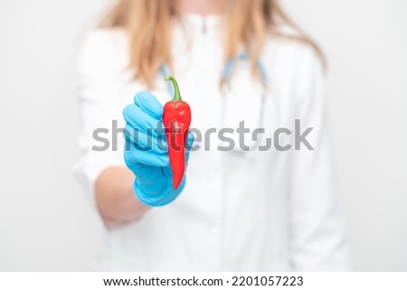red chili pepper in the hands of a scientist or doctor. scientific research of red pepper, capsaicin.