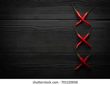 Red chili pepper on black wooden background
