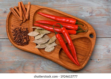 Red Chili Peppers, Cinnamon Rolls On A Wooden Surface