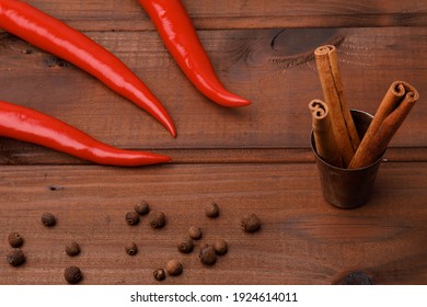 Red Chili Peppers, Cinnamon Rolls On A Wooden Surface