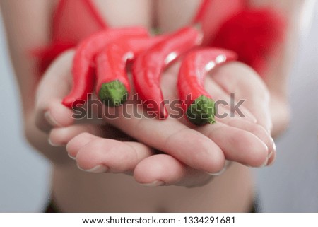Red chilli peppers in girl's hands
