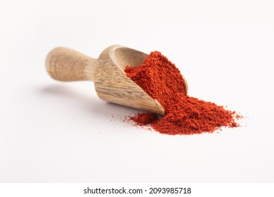 Red chilli powder in a wooden measuring scoop or spoon on a white background - Shutterstock ID 2093985718