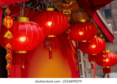 Red Chinese lanterns with golden accents hanging in row, celebration and tradition - Powered by Shutterstock