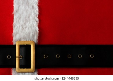 Red Christmas Background Of Santa Suit With Belt And Gold Buckle.