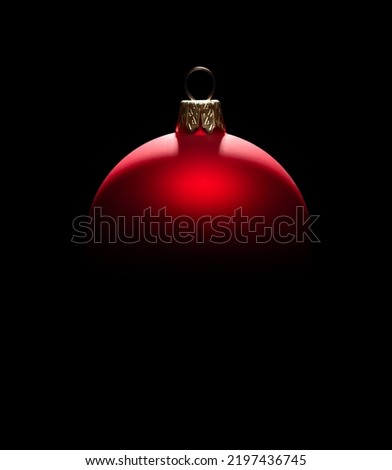 Red Christmas ball in backlight on black background
