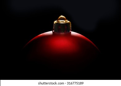 red Christmas ball in tense light on black background
