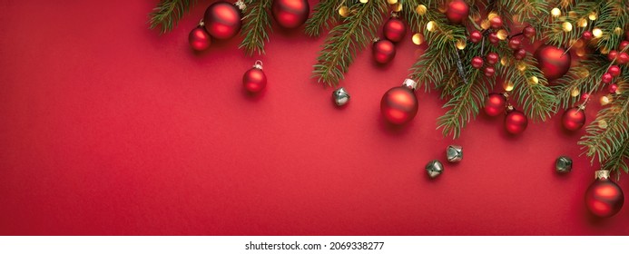 Red Christmas banner with fir branches, lights and decorations . - Shutterstock ID 2069338277