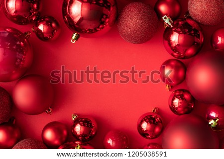 Red Christmas baubles decoration on red background with copy space. New Year greeting card. Minimal style.  Flat lay.