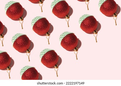 Red Christmas Baubles In Paper Cupcake Liners, Creative Pattern Against Pastel Pink Background. Traditional Winter Holidays Baking Idea. 