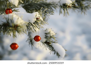 Red Christmas bell hangs on a snow-covered branch of a Christmas tree against a festive background of white snow and golden bokeh lights with copy space. New Year, greeting and holiday card, banner. - Powered by Shutterstock