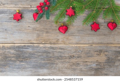 Red christmas decoration, berries and fir tree branches on old wooden background; Christmas greeting card template - Powered by Shutterstock